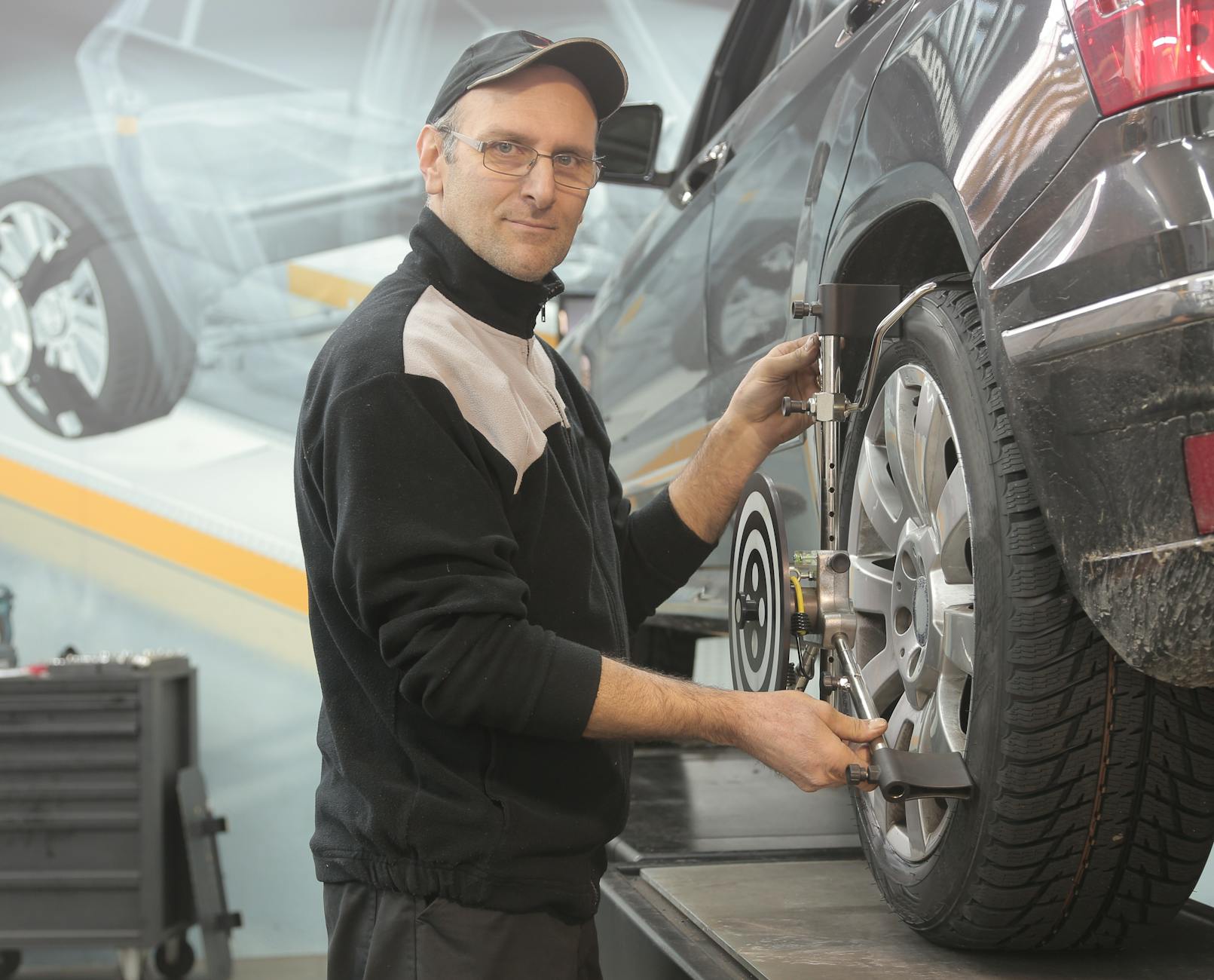 man in black jacket standing beside black car